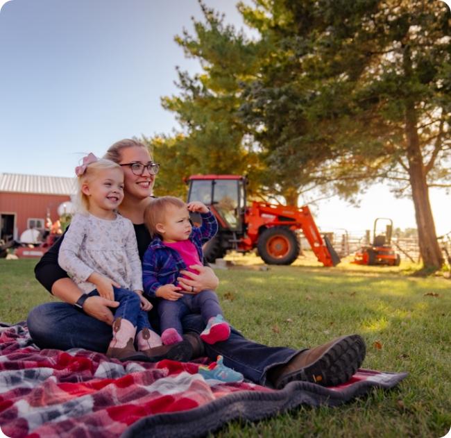 woman with children on blanket in lawn