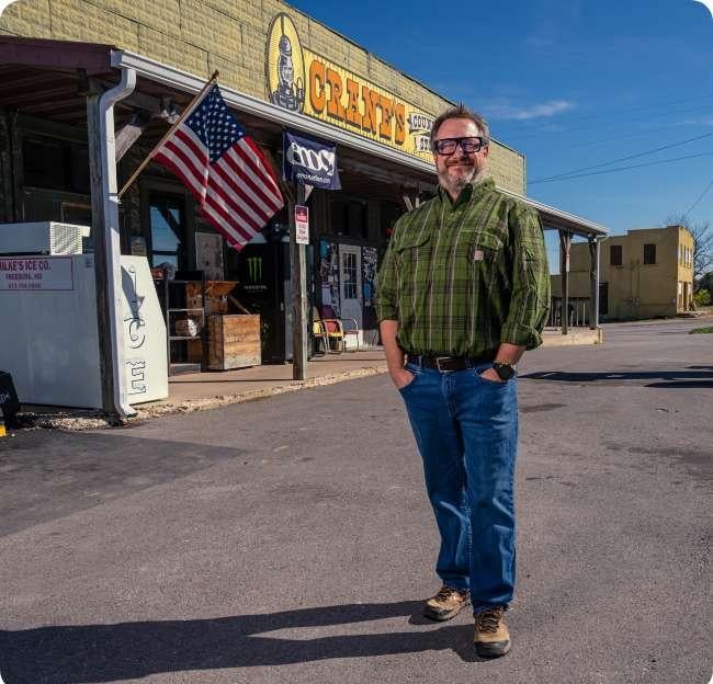 guy standing outside store smiling
