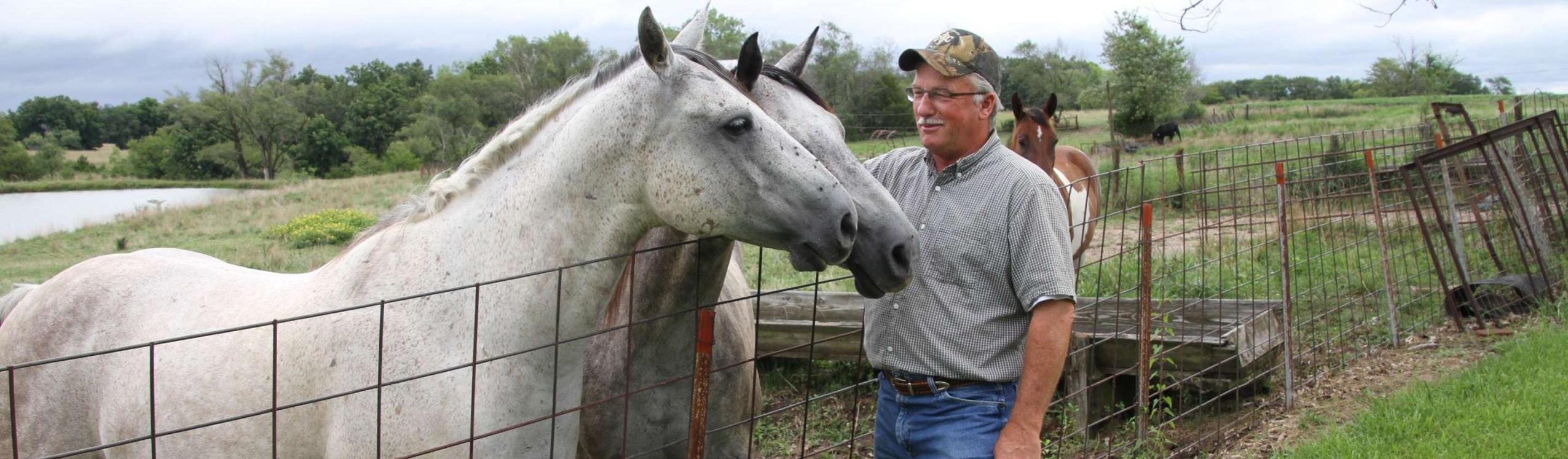 man petting horse