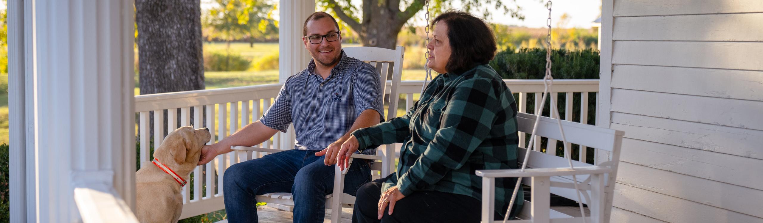 Mom and son on porch with dog